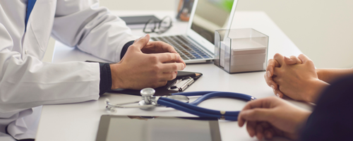 Image of a dicussion in a consultation room with a patient sourced from Canva.com